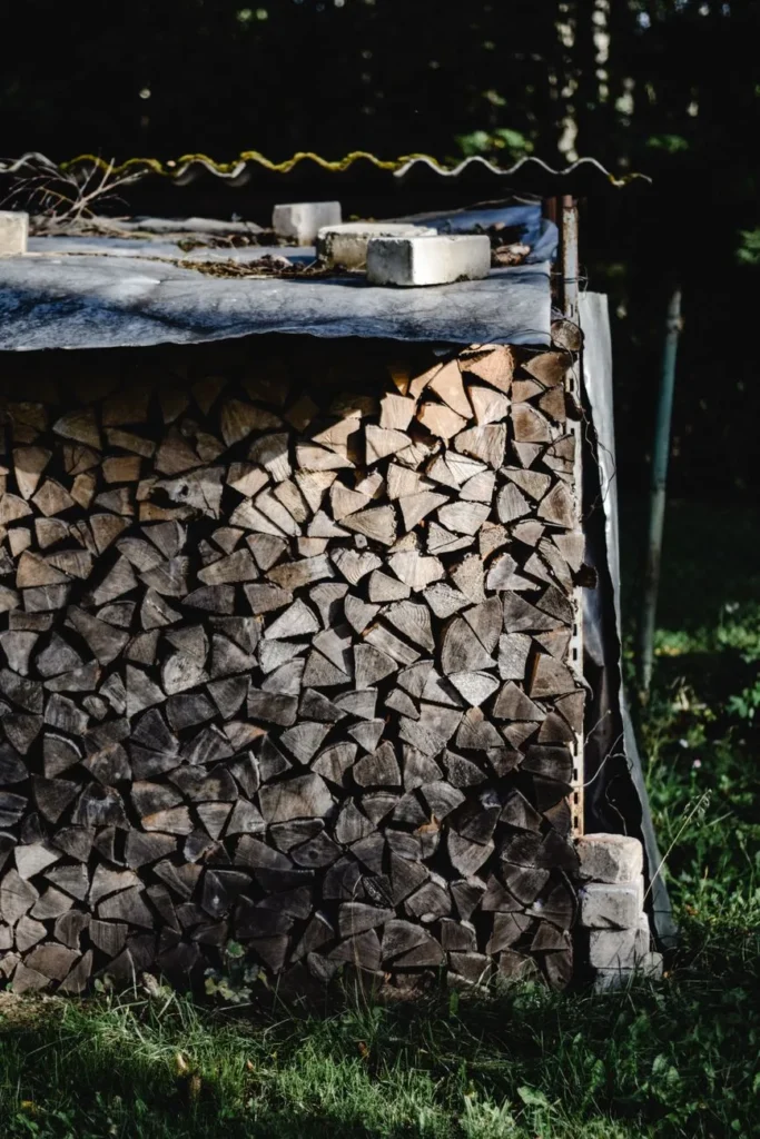 Gekloofd brandhout netjes opgestapeld in de tuin, afgedekt tegen de regen zodat het kan drogen
