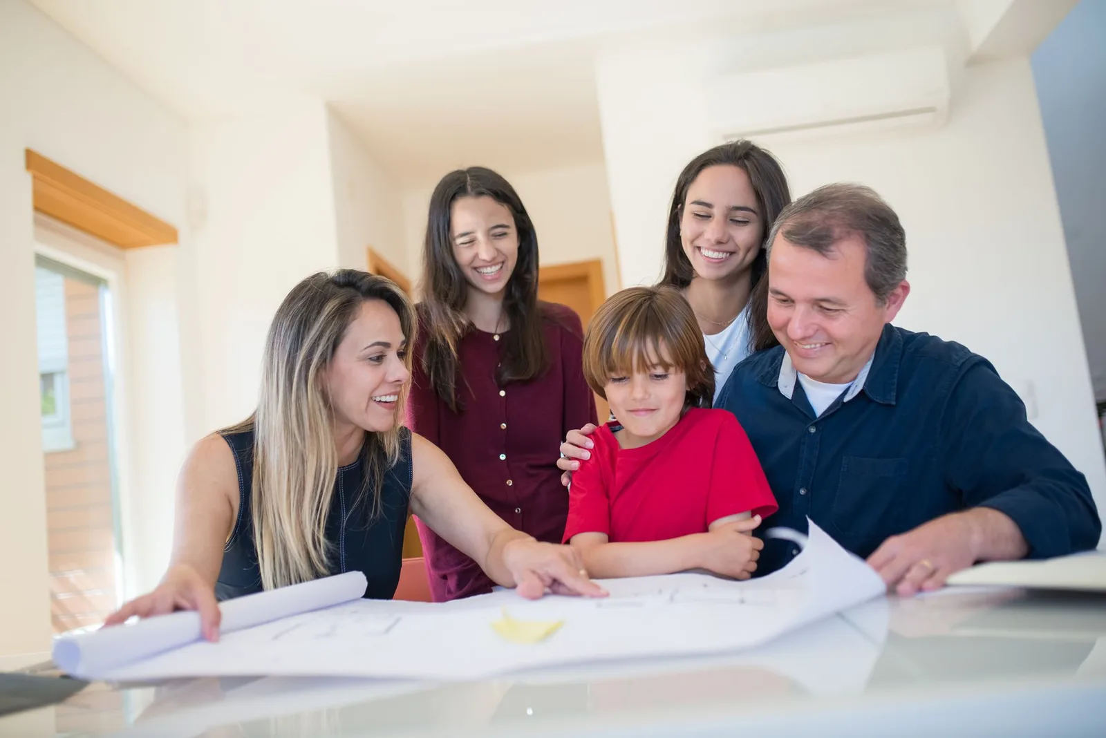 Gezin bekijkt samen een plattegrond van het huis aan tafel om een vluchtplan voor brand te maken