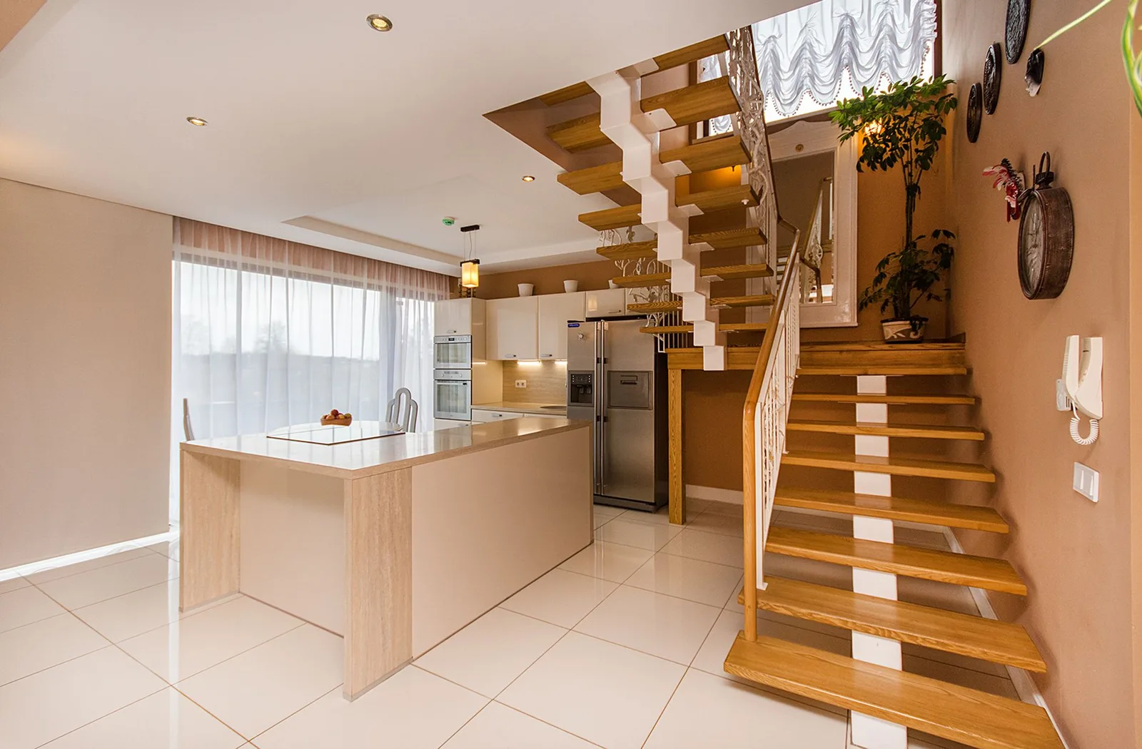 Open keuken met kookeiland en een houten trap naar boven in dezelfde ruimte